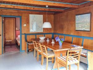een eetkamer met een houten tafel en stoelen bij Holiday Home Jorid - 300m from the sea in Western Jutland by Interhome in Vejers Strand