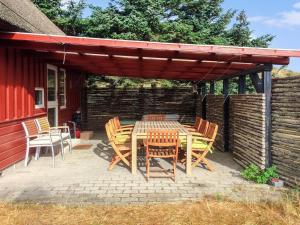 a patio with a table and chairs under a pergola at Holiday Home Jorid - 300m from the sea in Western Jutland by Interhome in Vejers Strand