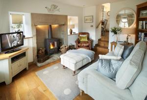 a living room with a couch and a fireplace at Winsmore Cottage in Bakewell