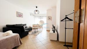 - un salon avec un canapé noir et une table dans l'établissement Oura Lancemar by Sunny Deluxe, à Albufeira