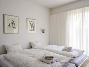 um quarto branco com 2 camas e uma janela em Holiday Home Casa Carina by Interhome em Carona