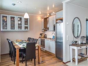 a kitchen and dining room with a table and a refrigerator at Holiday Home Tahkonkallio 34 b by Interhome in Tahkovuori