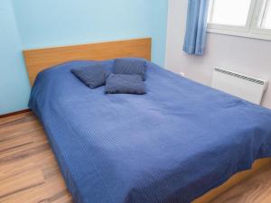 a blue bed with two pillows on top of it at Holiday Home Tahkonkallio 34 b by Interhome in Tahkovuori