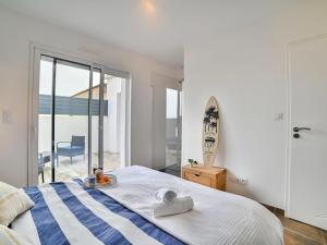 - une chambre avec un lit et une planche de surf dans l'établissement Holiday Home Les Salines by Interhome, à Grand-Village-Plage