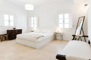 um quarto branco com 2 camas e um espelho em 3-Room Family Villa with Massive Pool, Central Location, Seconds from Cliff! em Imerovigli
