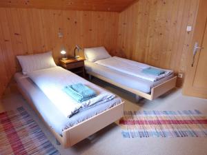 a room with two beds and a table with a lamp at Apartment Vreneli by Interhome in Lauterbrunnen