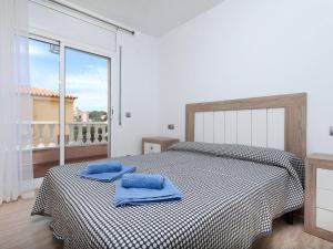 ein Schlafzimmer mit einem Bett mit zwei blauen Handtüchern darauf in der Unterkunft Villa Paraiso by Interhome in L'Ametlla de Mar