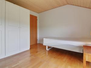 a bedroom with a bed and a wooden floor at Holiday Home Amalia - 500m from the sea in NW Jutland by Interhome in Hjørring