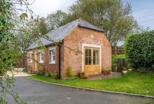 een rood bakstenen huis met een tuin en een oprit bij Inkpen Cottage in Robertsbridge +4 foto's