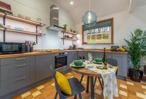 een keuken met een tafel en stoelen en een eetkamer bij Inkpen Cottage in Robertsbridge