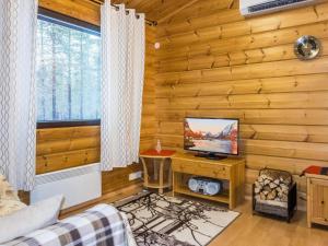 a living room with a television in a log cabin at Holiday Home Naalitupa by Interhome in Saariselka