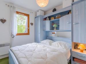 1 dormitorio con 1 cama grande con estanterías azules en Apartment Les Sylvestres by Interhome, en Cabourg