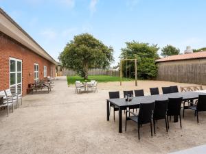 a patio with a table and chairs and a playground at Holiday Home Saga by Interhome in Bredebro