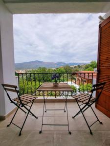 una mesa y sillas en un balcón con vistas en Hotel Karagiannis, en Limenaria