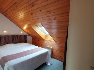 1 dormitorio con cama blanca y techo de madera en Apartment La Malouinière des Longchamps-4 by Interhome, en Saint-Jouan-des-Guérets
