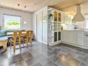 a kitchen and dining room with a table and chairs at Holiday Home Aku - 24km from the sea in Western Jutland by Interhome in Højer