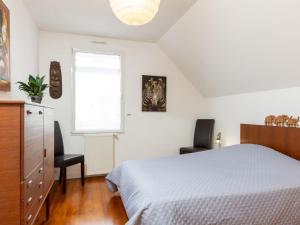Un dormitorio con una cama y dos sillas y una ventana. en Holiday Home Les Agapanthes by Interhome, en Dinard