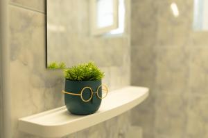a potted plant sitting on a shelf in a bathroom at Luxury 2 bedroom holiday apartment in Piteşti