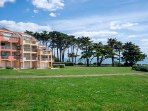ein Mehrfamilienhaus mit einer Wiese und Bäumen in der Unterkunft Apartment Claire Marine by Interhome in Pornic