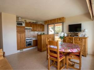 eine Küche mit einem Tisch mit einer Vase mit Blumen darauf in der Unterkunft Apartment Claire Marine by Interhome in Pornic