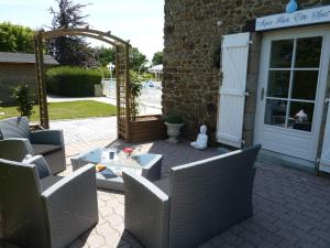a patio with chairs and a table in front of a building at Studio Le studio by Interhome in Saint-Jouan-des-Guérets