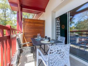 een patio met een tafel en stoelen op een balkon bij Apartment Villa Marine by Interhome in Seignosse
