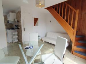 comedor con mesa de cristal y sillas blancas en Apartment La Malouinière des Longchamps-3 by Interhome, en Saint-Jouan-des-Guérets