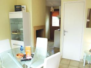 聖茹昂代蓋雷特的住宿－Apartment La Malouinière des Longchamps-3 by Interhome，厨房配有玻璃桌和白色椅子