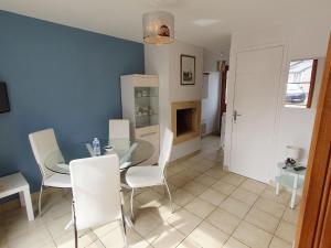 una sala da pranzo con tavolo in vetro e sedie bianche di Apartment La Malouinière des Longchamps-3 by Interhome a Saint-Jouan-des-Guérets