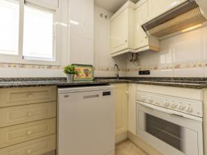 cocina con armarios blancos y lavavajillas blanco en Apartment Girona by Interhome, en Cubelles