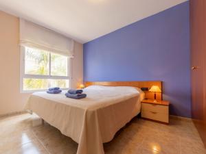 Un dormitorio azul con una cama con toallas. en Apartment Girona by Interhome, en Cubelles