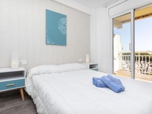 - une chambre avec un lit blanc et une grande fenêtre dans l'établissement Apartment Montseny by Interhome, à Sant Antoni de Calonge