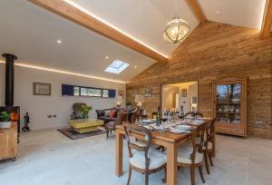 a dining room and living room with a table and chairs at Downbridge Lodge in Hoxne