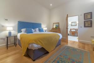 a bedroom with a large bed with a yellow blanket at Downbridge Lodge in Hoxne