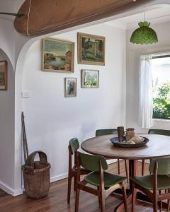 a dining room with a table and chairs at The Bakers Cottage - Crescent Head in Crescent Head