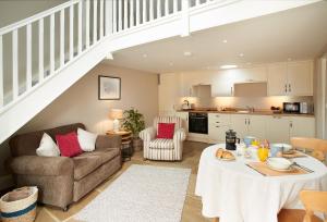 a kitchen and living room with a table and a couch at Kirby Cottage in Harome