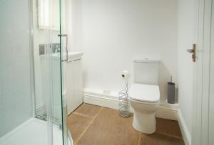 a bathroom with a toilet and a glass shower at Kirby Cottage in Harome