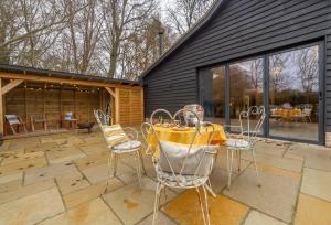 a patio with a table and chairs on it at Downbridge Lodge in Hoxne