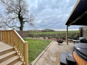 a backyard with a wooden deck and a grill at Spinney View Huts 