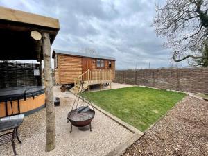 a backyard with a log cabin and a swing at Spinney View Huts 