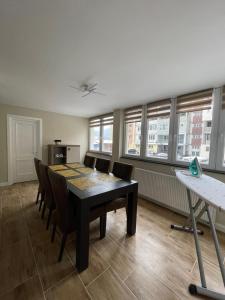 a dining room with a table and chairs and windows at Apartament 1 Lalelelor in Năsăud