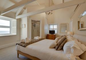a bedroom with a large bed and a window at Harbour Masters House in Craster