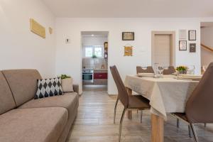 salon z kanapą i stołem w obiekcie R&B Family Apartments w mieście Sveti Filip i Jakov