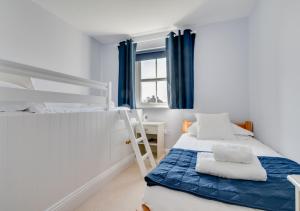 a bedroom with two bunk beds and a desk at Seasalt in Swinhoe