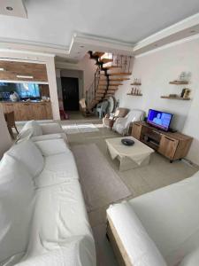 sala de estar con sofá blanco y TV en 4 ROOMS SUMMER VİLLA KUNDU ANTALYA, en Aksu