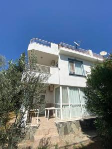 una gran casa blanca con una escalera delante de ella en 4 ROOMS SUMMER VİLLA KUNDU ANTALYA, en Aksu