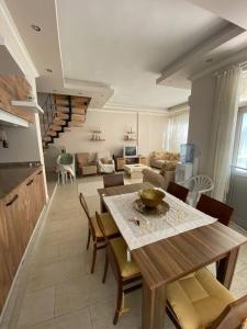 cocina y sala de estar con mesa y sillas en 4 ROOMS SUMMER VİLLA KUNDU ANTALYA, en Aksu
