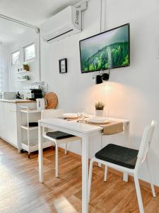 a white dining room with a white table and chairs at Nordin Apartman in Hódmezővásárhely