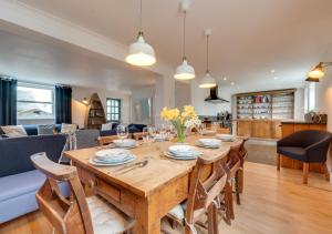 a dining room and living room with a table and chairs at Coastguard Cottage in Craster