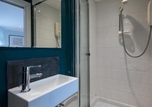 a bathroom with a sink and a shower at Coastguard Cottage in Craster